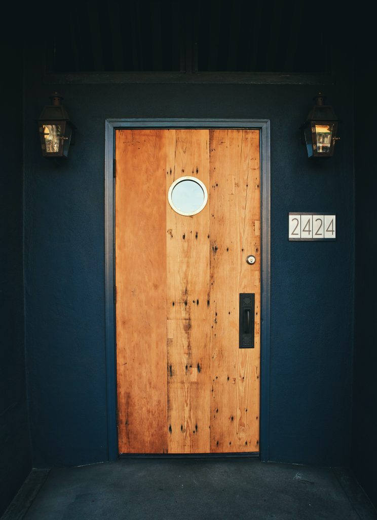 Wooden front door in modern apartment with a smooth black door handle