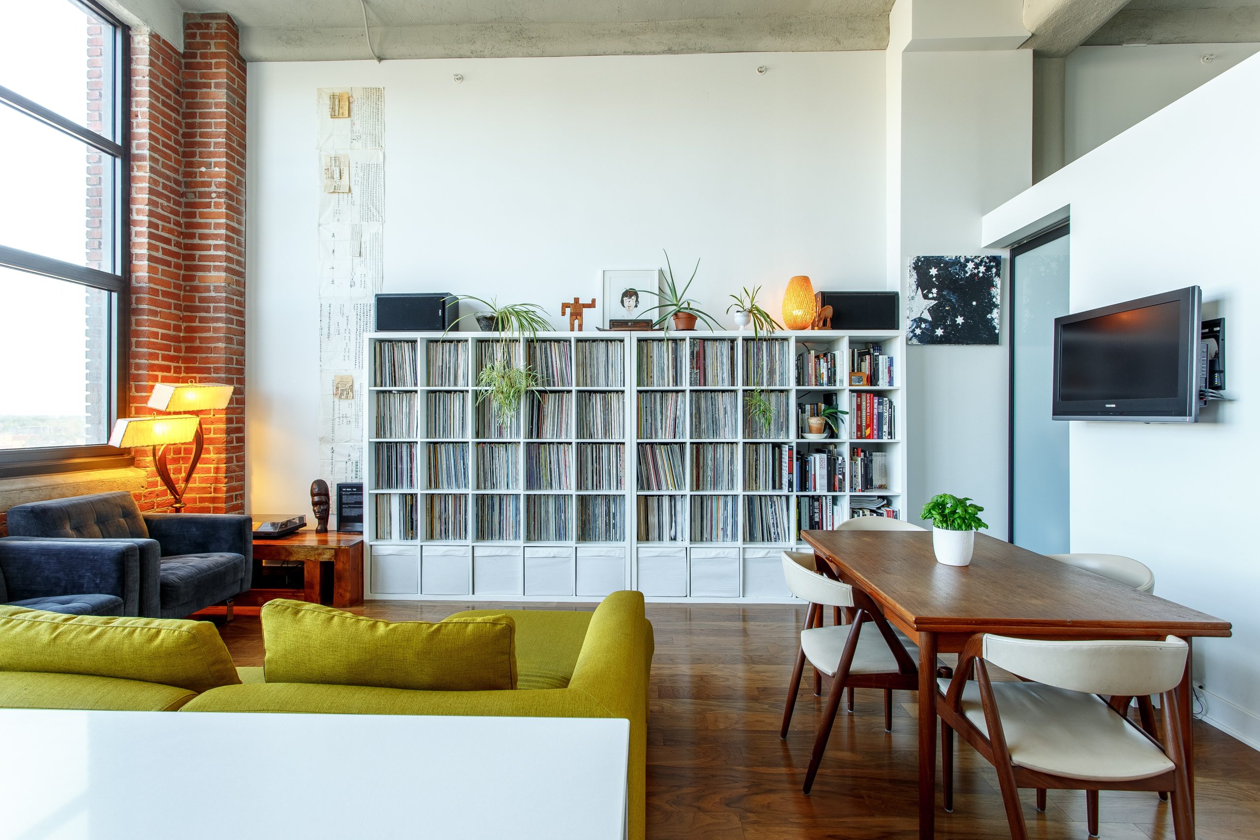 neo industrial apartment with a velvet sofa and exposed brick walls