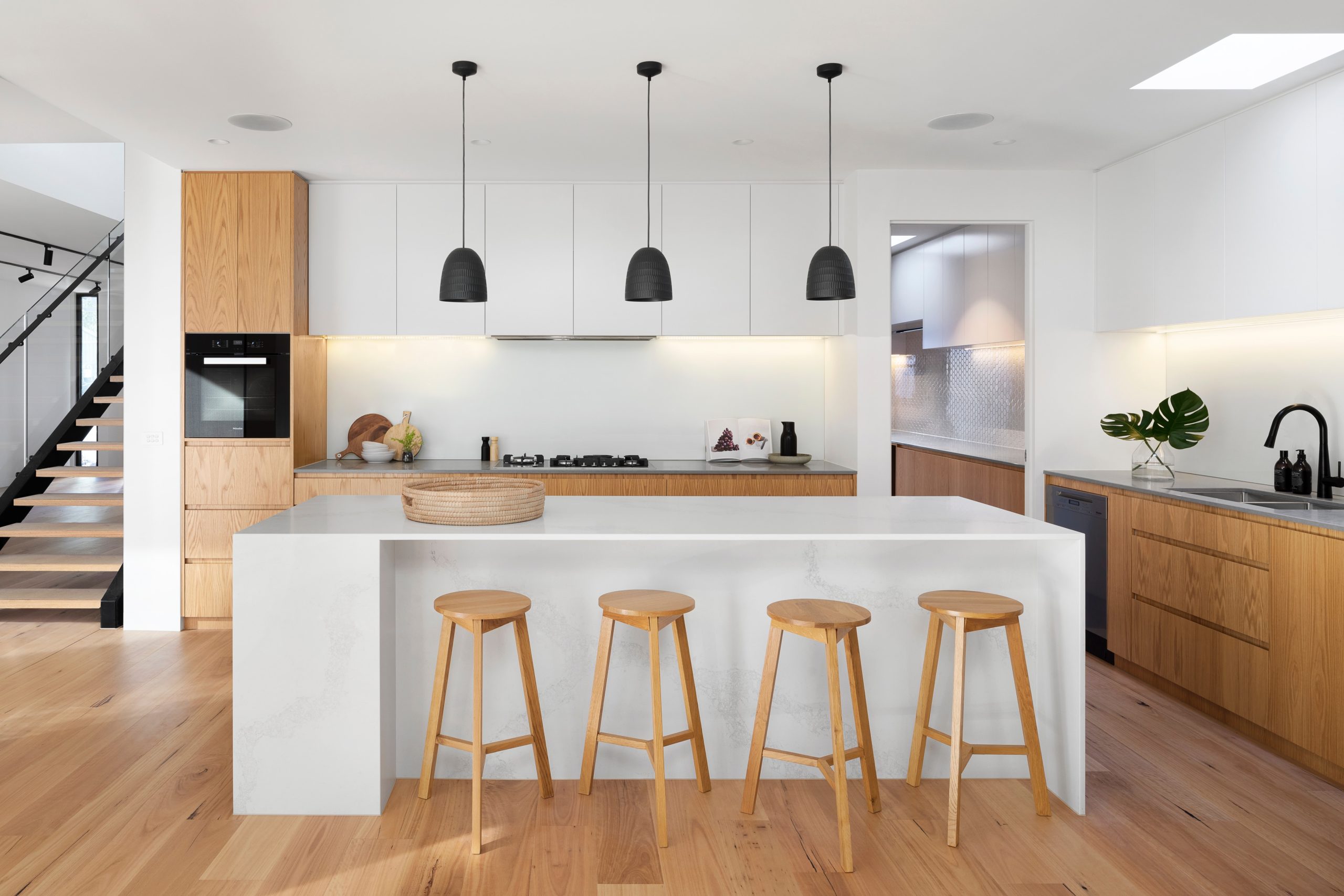 Japandi style kitchen with wooden stools around a kitchen island